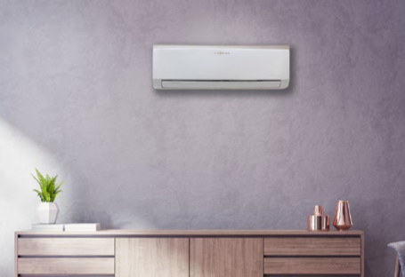 Une main qui tient une télécommande blanche de climatiseur pour régler la température.