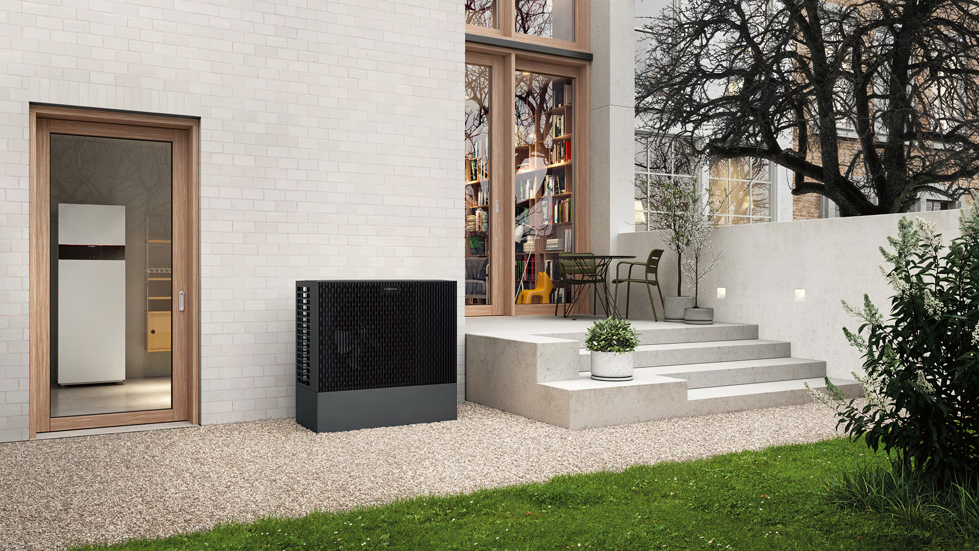 Unité de pompe à chaleur fixée sur un mur de briques à côté d'une porte d'entrée.