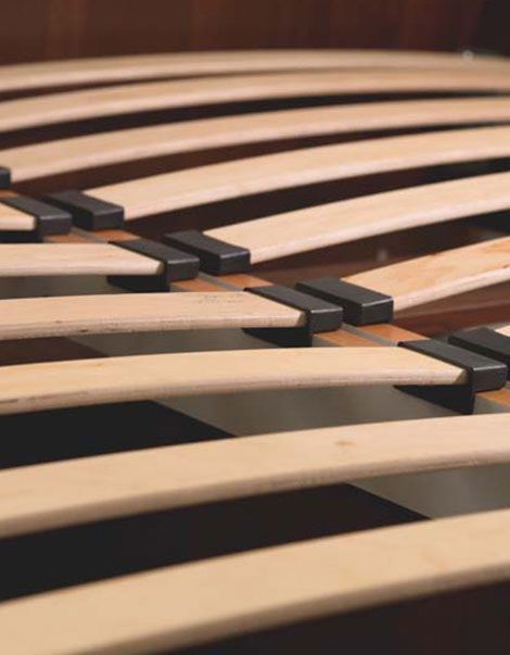 Un primer plano de un marco de cama con listones de madera.