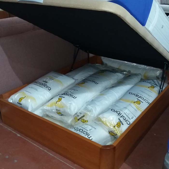 Una caja de madera llena de almohadas de microfibra