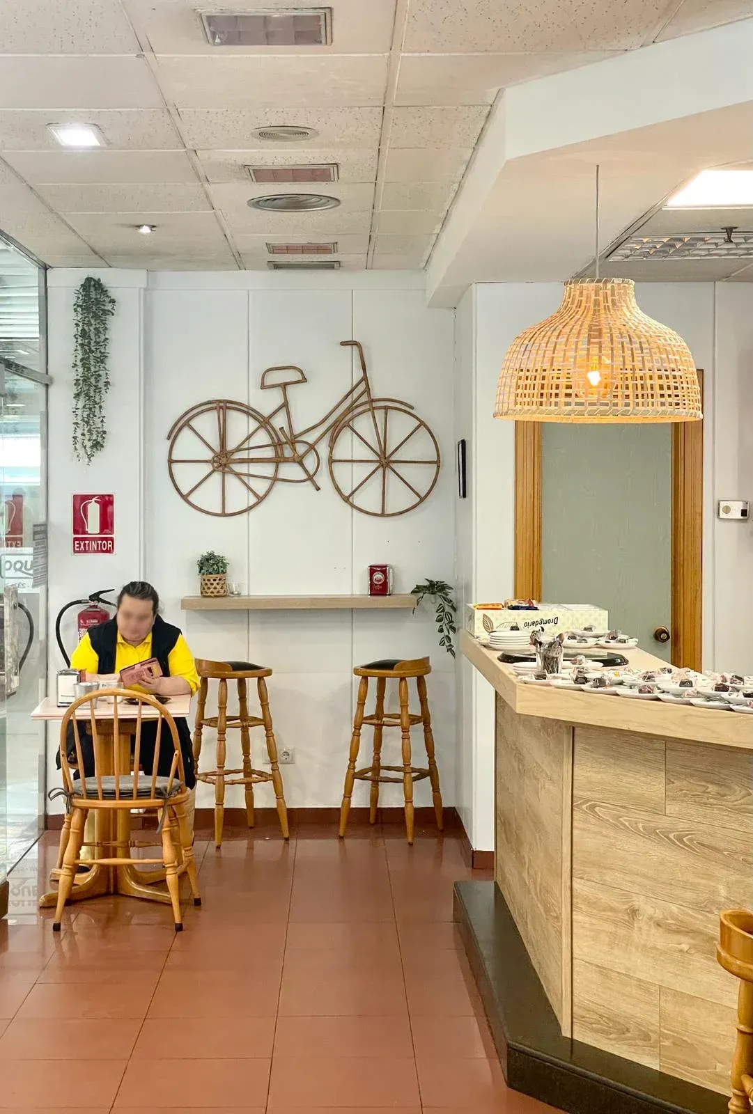 Un hombre está sentado en una mesa en un restaurante mirando su teléfono.