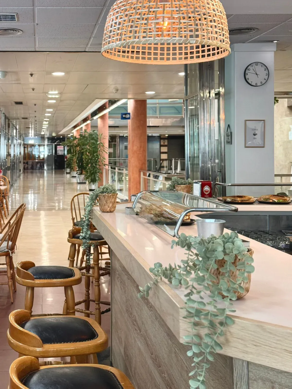 Un bar con taburetes y un reloj en la pared.