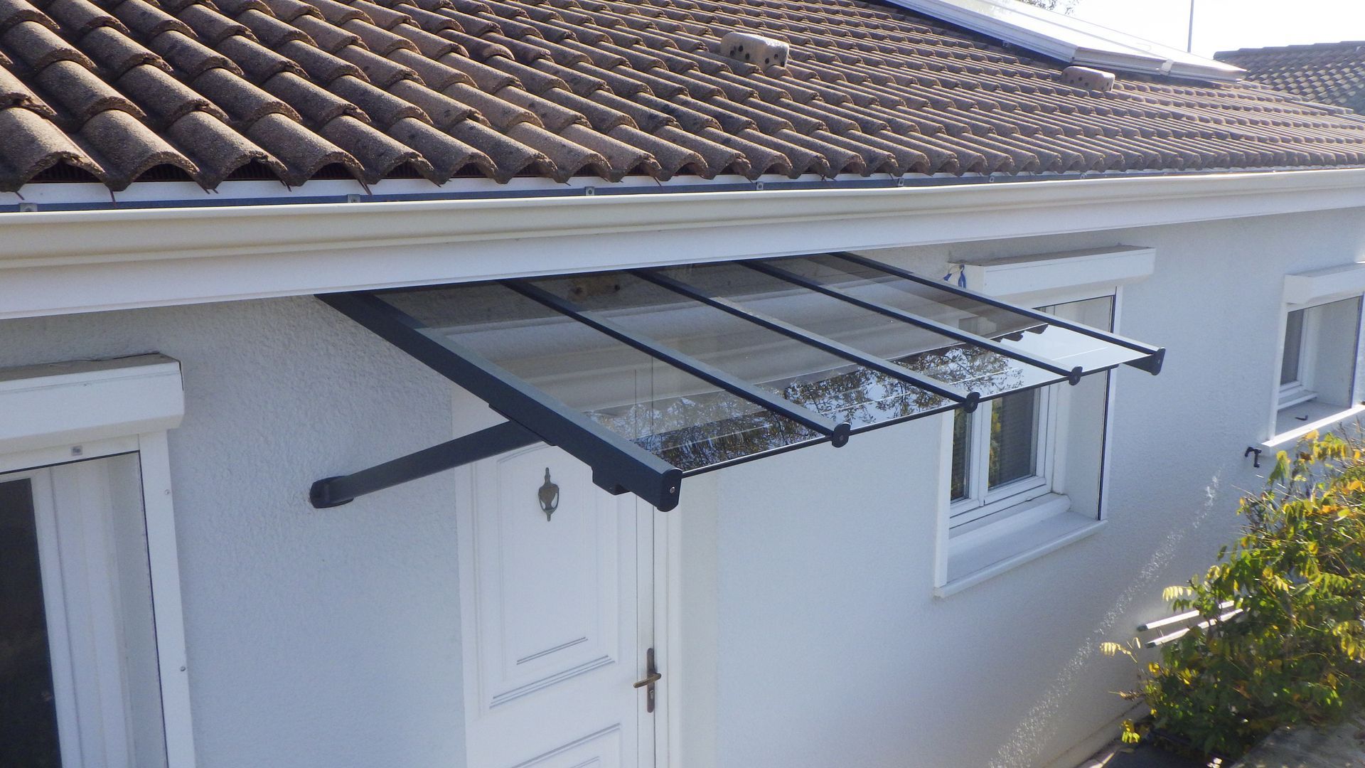 Marquise au-dessus d'une porte d'entrée blanche