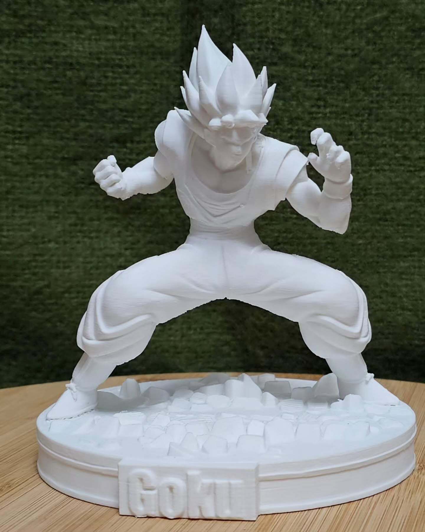 Una estatua de Goku de Dragon Ball Z está sentada en una mesa de madera.
