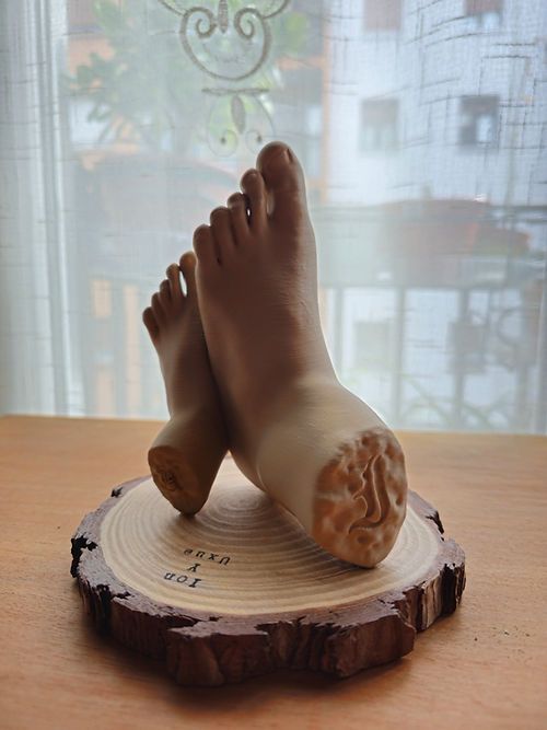 Un par de pies apoyados sobre una rodaja de madera sobre una mesa.