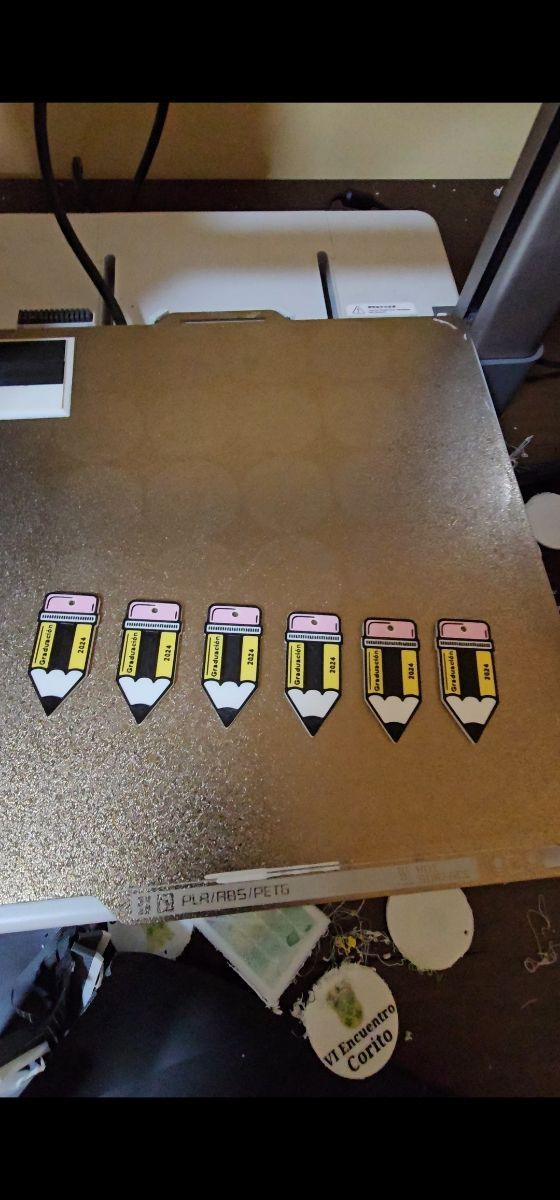Una computadora portátil con un montón de lápices encima