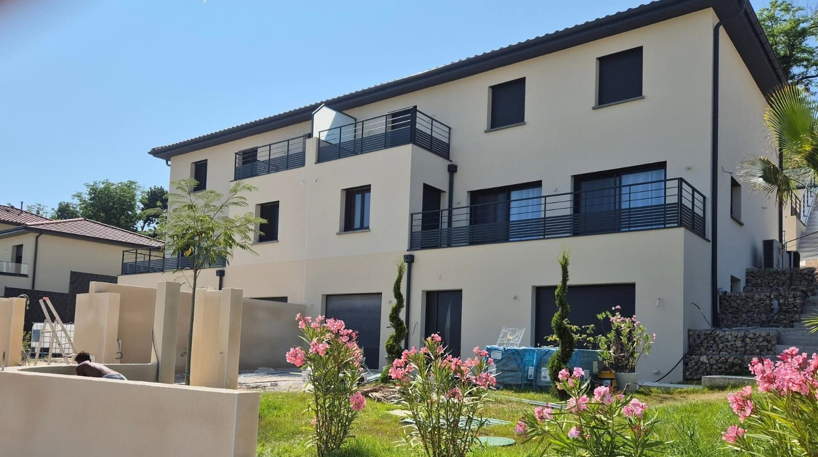 Maison avec échafaudage pendant la réparation du revêtement, avec toit rouge, revêtement jaune et pignon blanc.