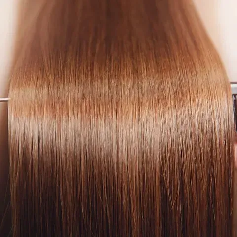Un primer plano del cabello de una mujer con una plancha.