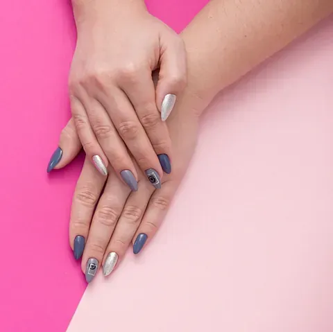 Manos de mujer con manicura sobre un fondo rosa y rosa.