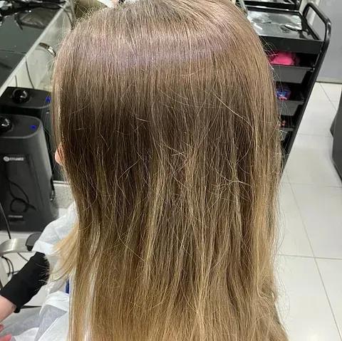 Una mujer se está peinando en un salón.