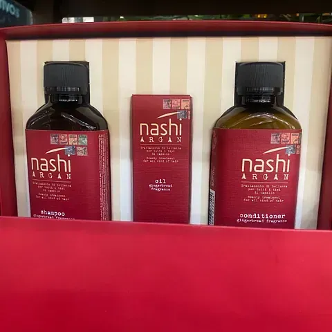 Tres botellas de Nashi Argan están en una caja roja.