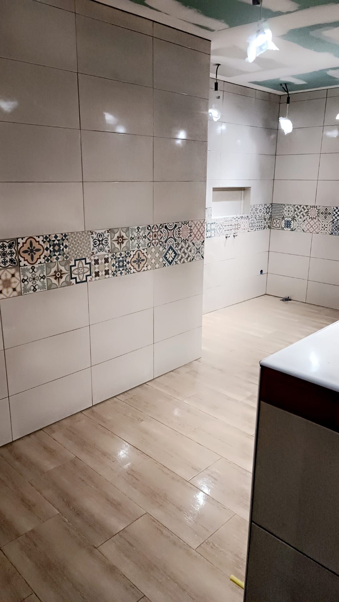 Salle de bains avec une frise sur le mur en carrelage