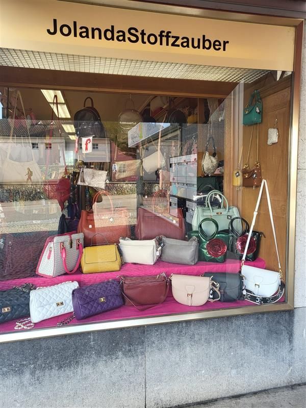 Ein Teller mit Croissants, aus einem davon wurde ein Biss herausgeschnitten, auf einem Holztisch.