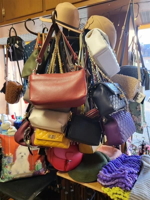 Drei Tassen Cappuccino stehen auf einem Holztisch neben Topfpflanzen.