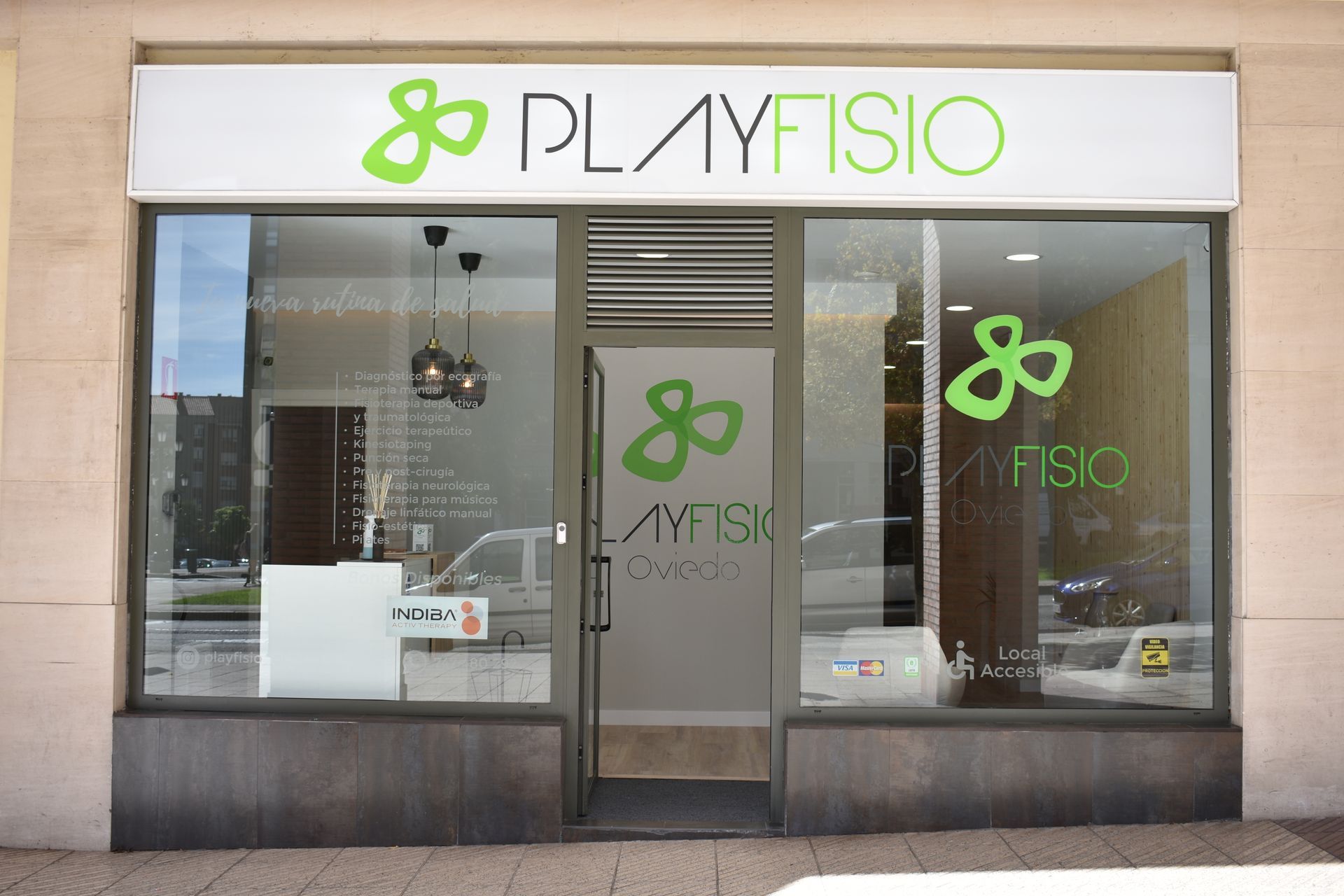 Clínica de fisioterapia PlayFisio con cartel luminoso, entrada principal.