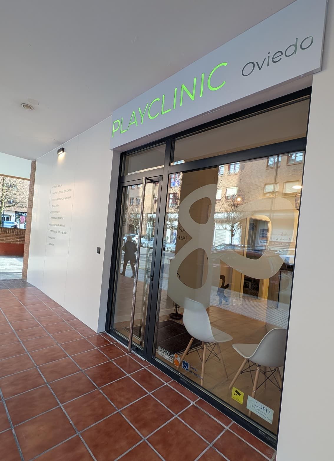 Clínica de fisioterapia PlayFisio con cartel luminoso, entrada principal.