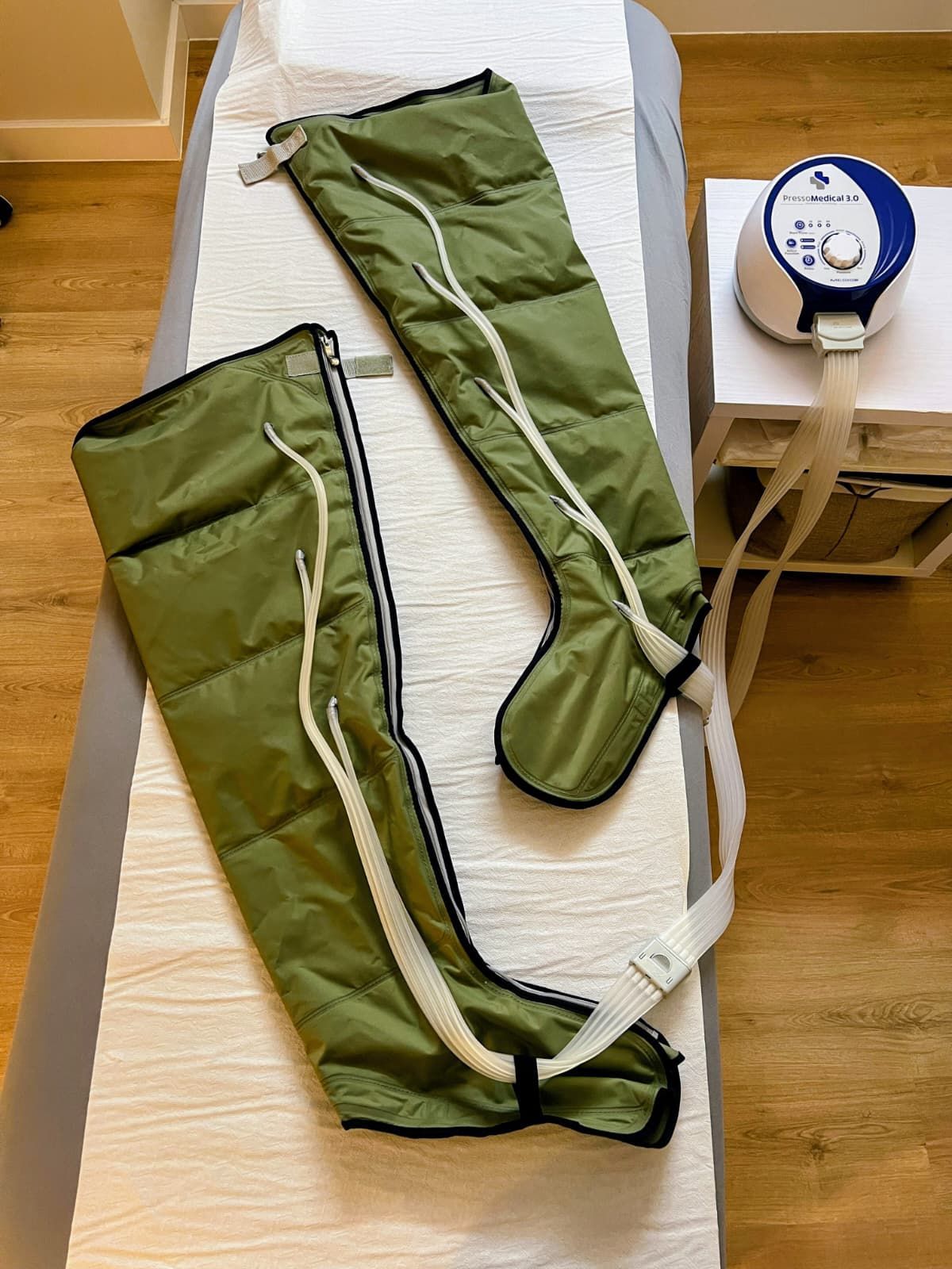 El dispositivo médico, Playnsio, incluye almohadillas, electrodos y un controlador portátil sobre un fondo oscuro.