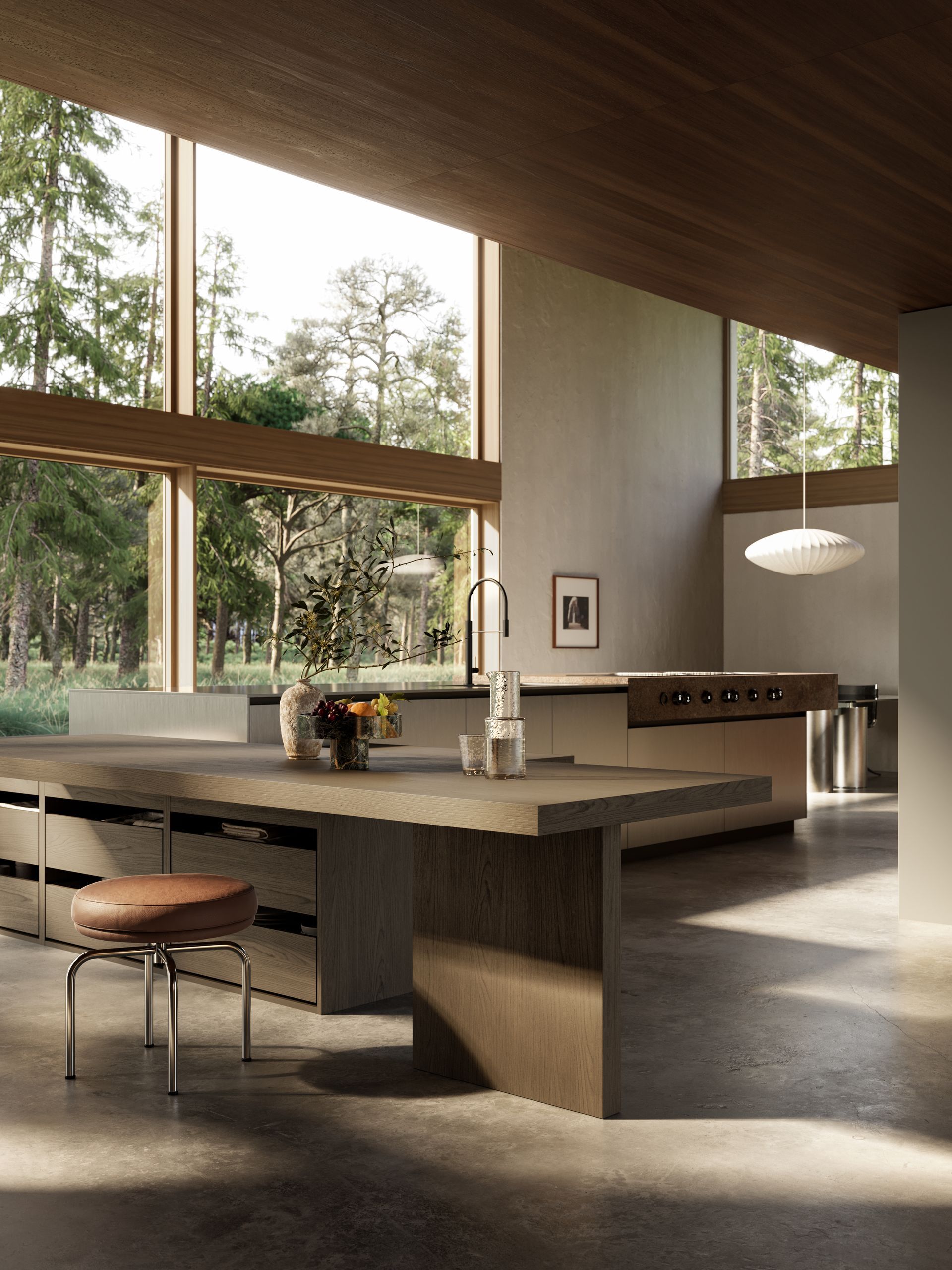 Cocina moderna con amplios ventanales con vistas al bosque. Muebles de madera, isla de piedra y un taburete.