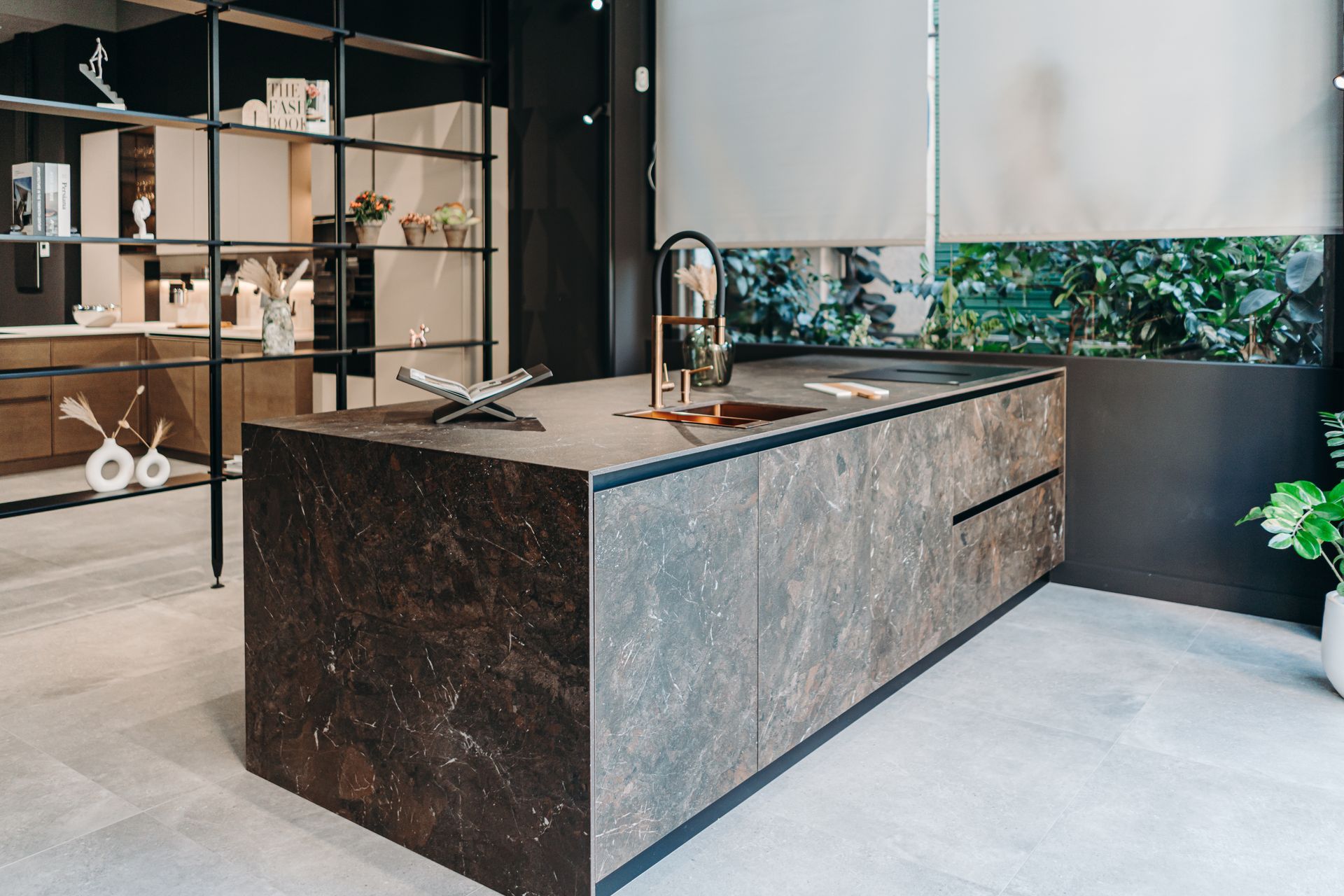 Isla de cocina moderna con encimera de piedra oscura, fregadero y grifo integrados.