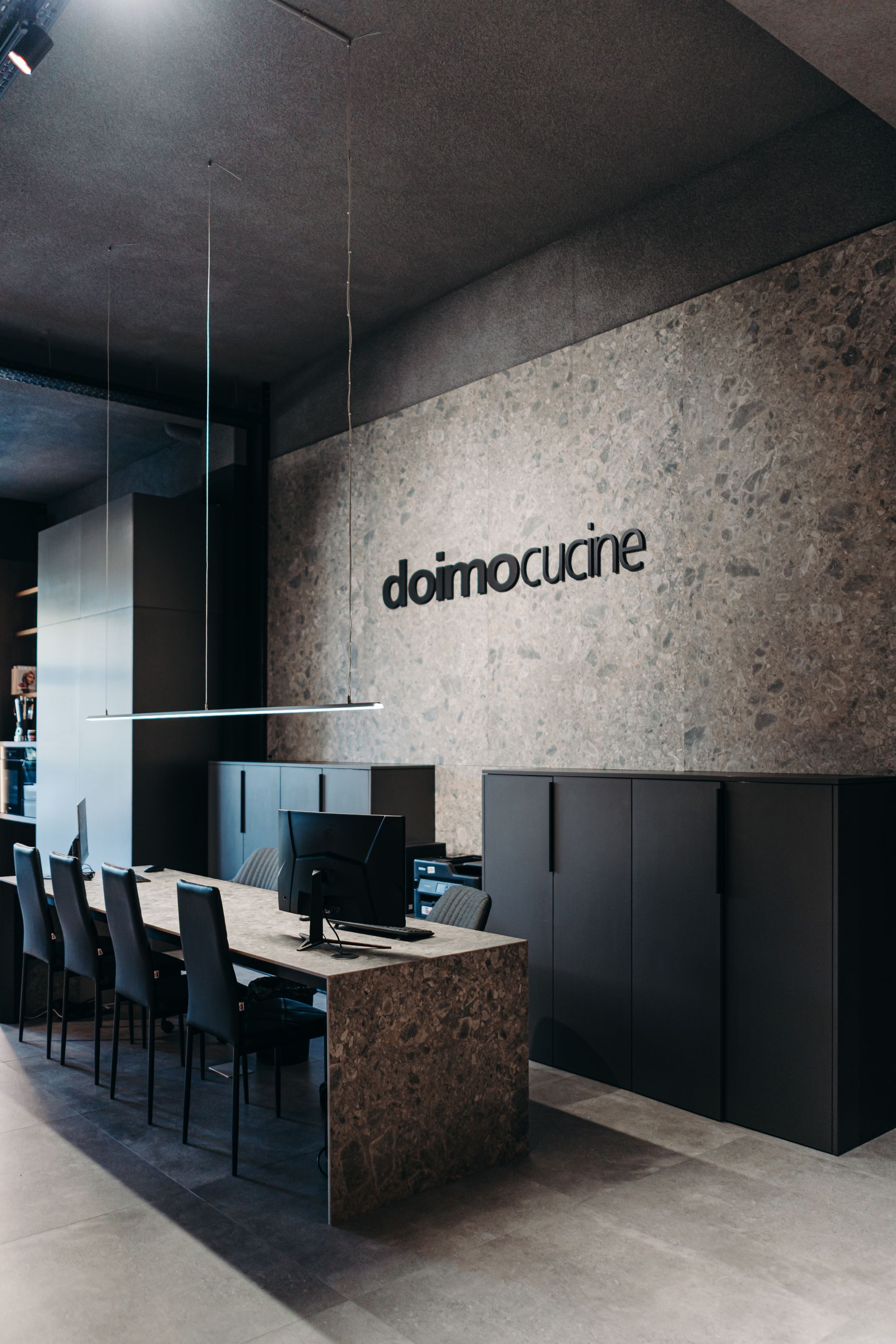 Interior de cocina moderna de exposición con detalles en piedra gris y el letrero 