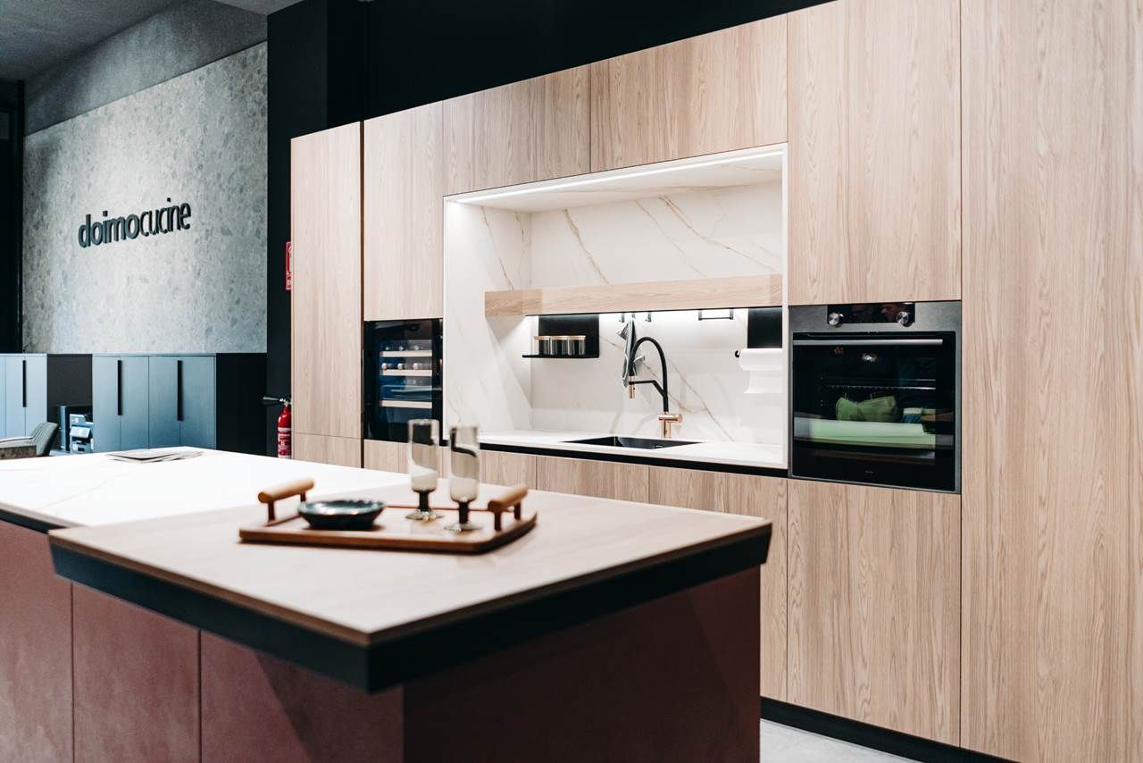 Cocina moderna con gabinetes de madera, electrodomésticos integrados y una isla central.