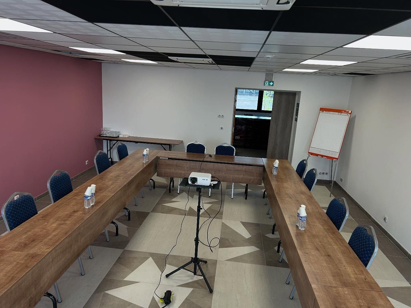 Salle de séminaire avec tableau et tables