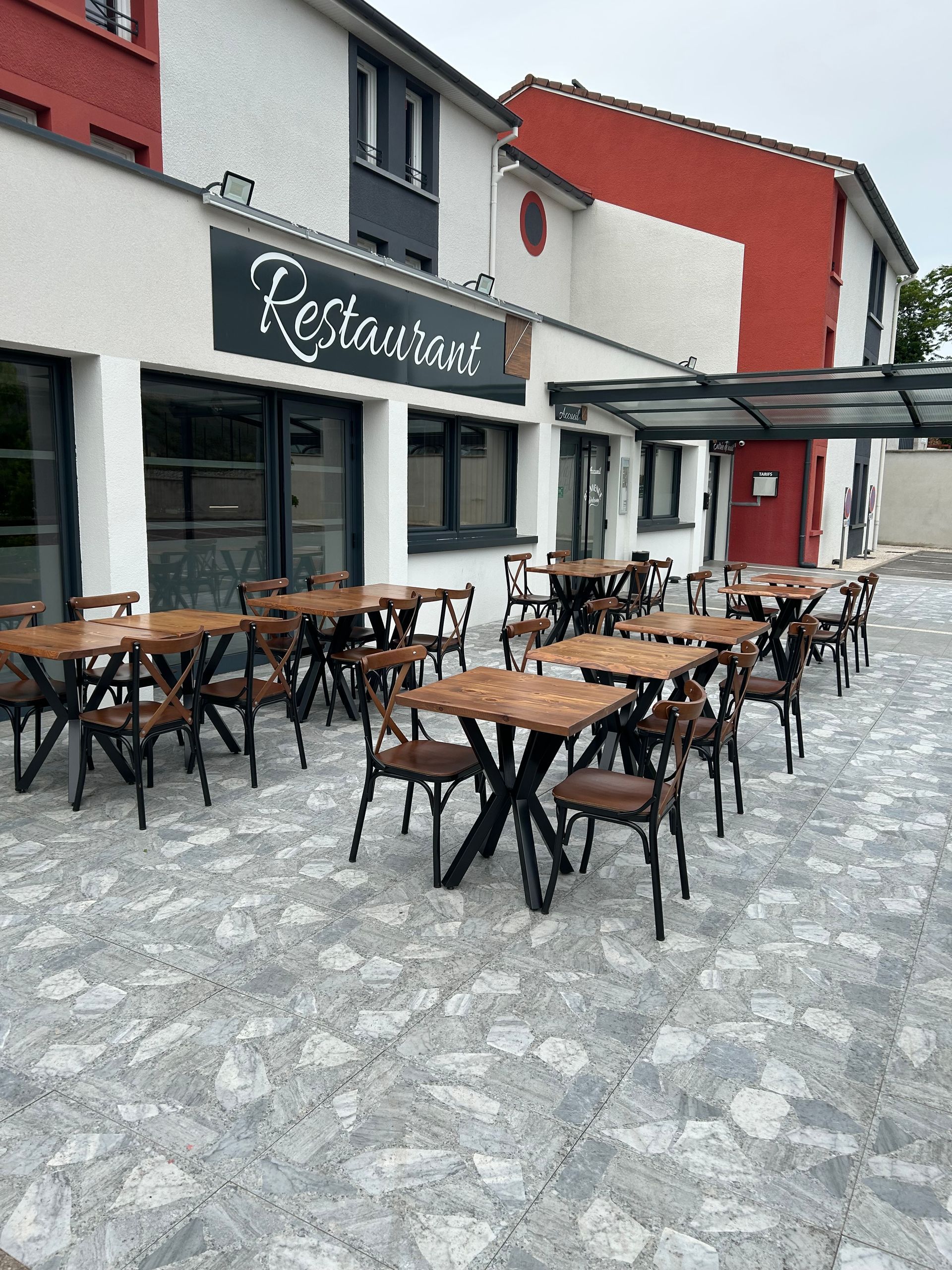 Devanture du restau avec terrasse, tables et chaises en bois