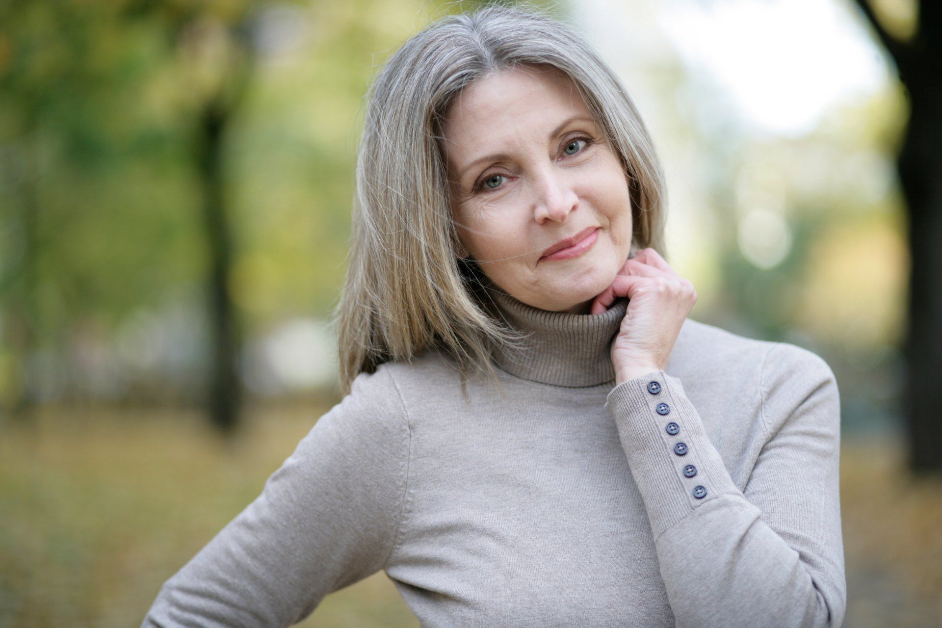 Wir freuen uns auf Sie: Eine herzlich lächelnde Frau im herbstlichen Park symbolisiert die persönliche Atmosphäre und die Zeit, die wir uns im Ästhetik Atelier Dörschner in Nürnberg für Ihre Fragen nehmen.
