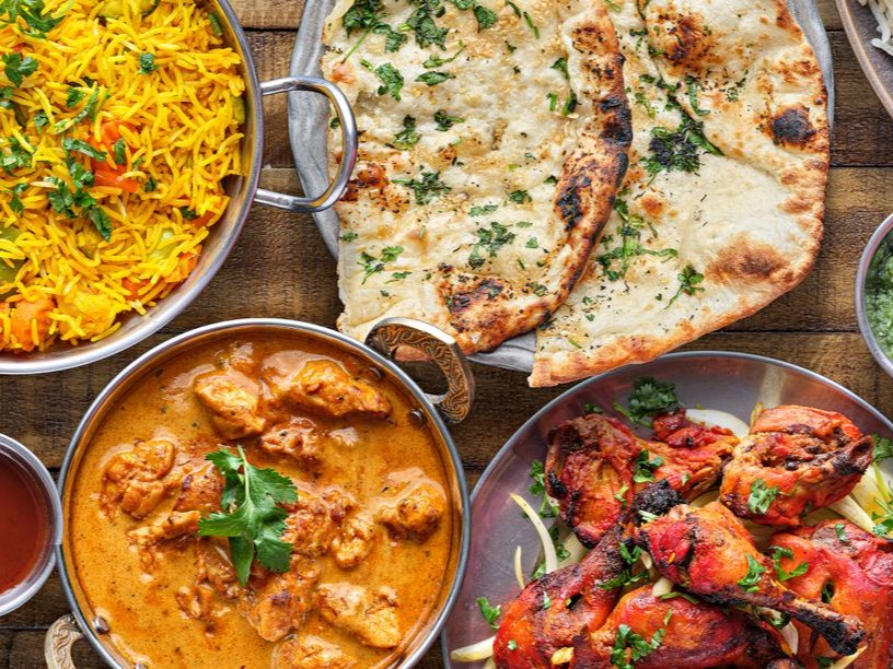 Assiette indienne : poulet tikka, curry, naan, riz et accompagnements.