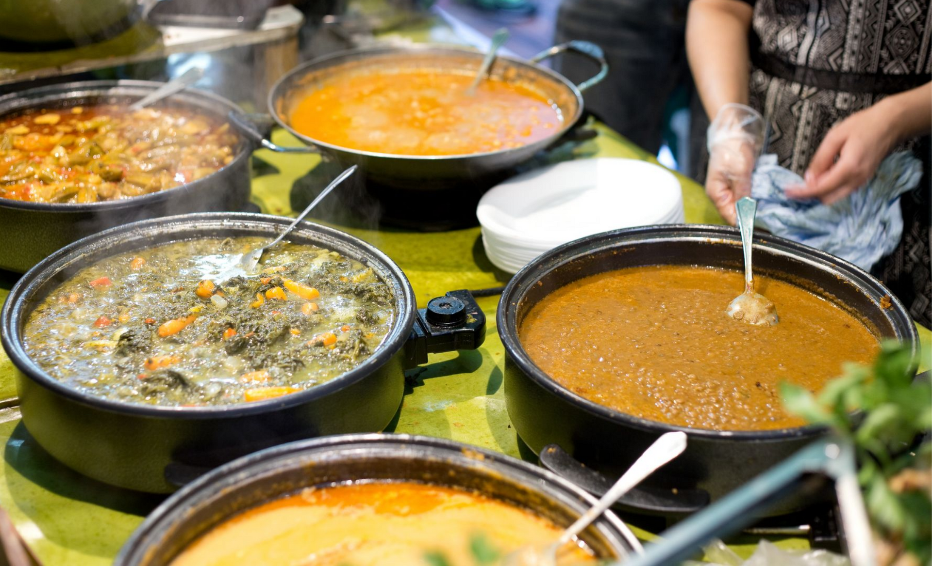 Plusieurs marmites de plats chauds disposées sur une table.