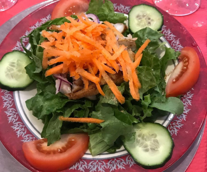 Salade dans une assiette avec laitue, tomates, concombres et carottes râpées.