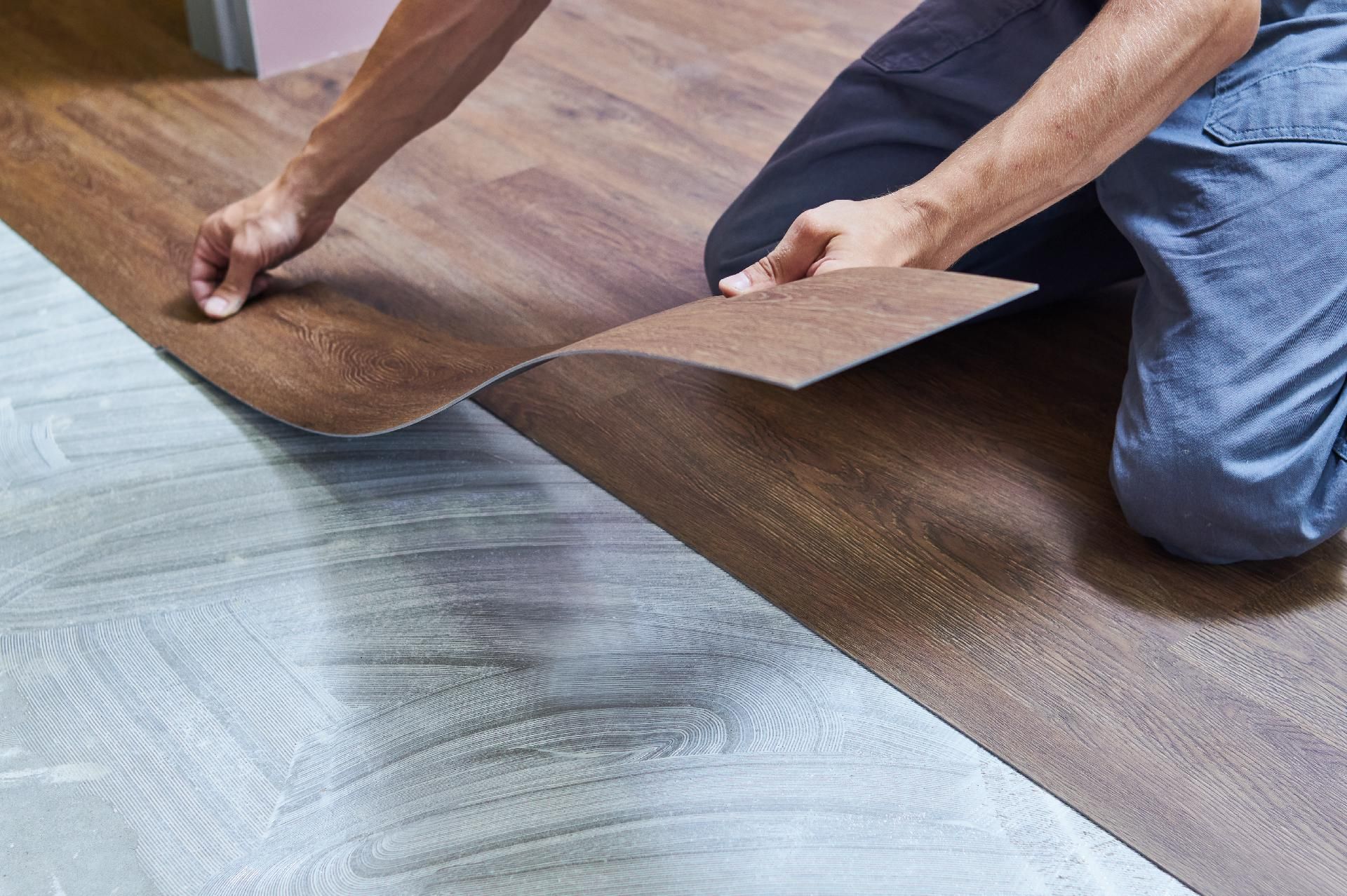 Arbeiter verlegt Vinylboden bei Hausrenovierung