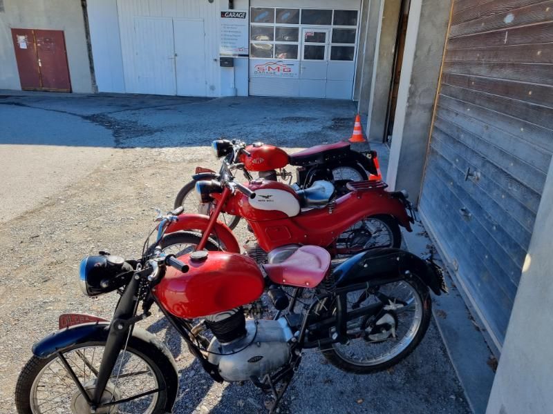 Drei rote Motorräder stehen vor einem Gebäude