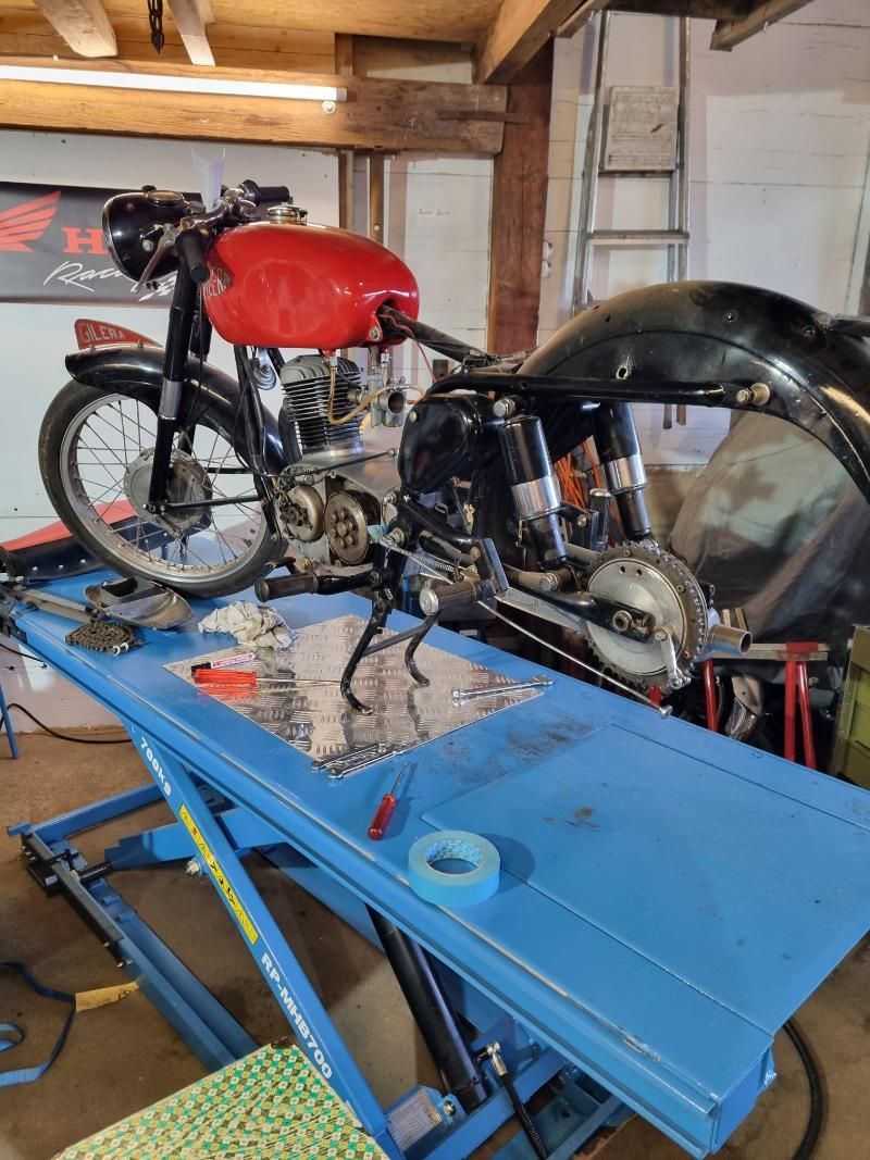 Ein rotes Honda-Motorrad steht auf einem blauen Tisch