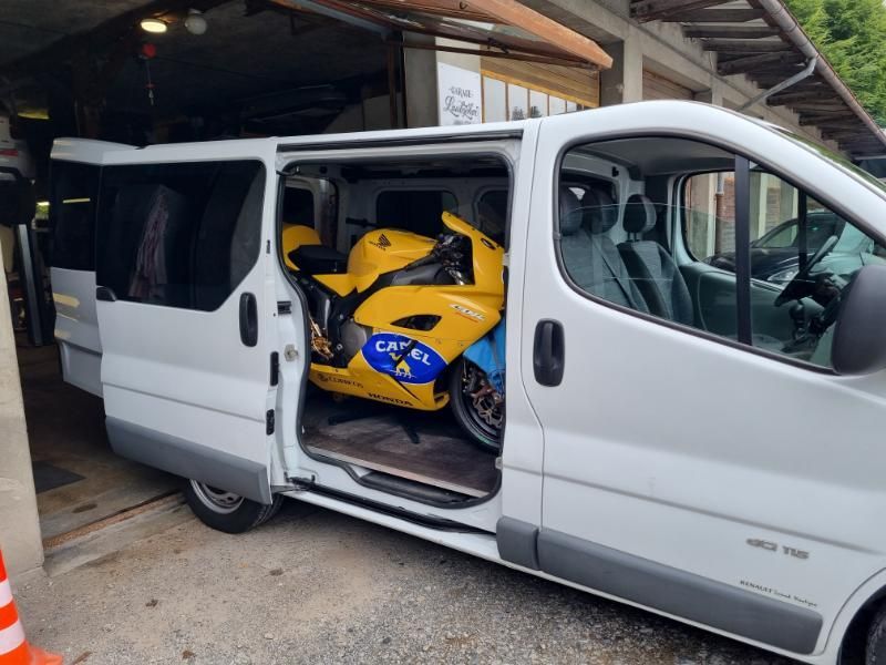 Ein gelbes Motorrad steht auf der Ladefläche eines weissen Lieferwagens