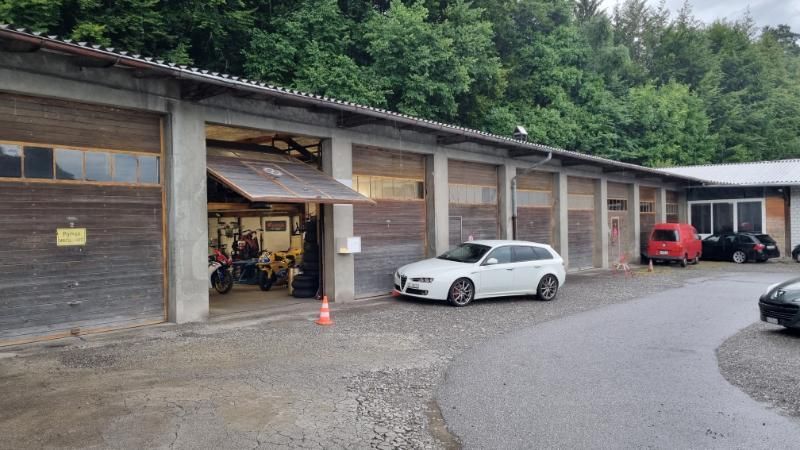 Ein weisses Auto steht vor einer Garage.