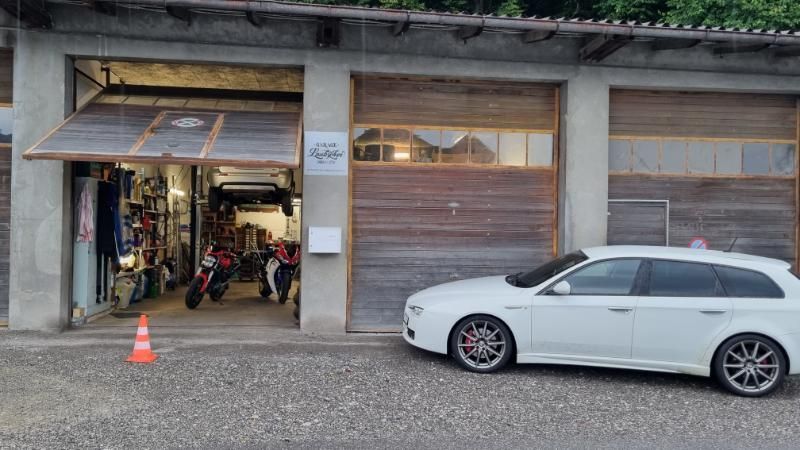 Ein weisses Auto steht vor einer Garage.