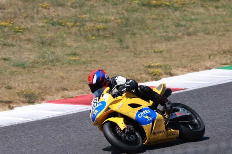 Ein Mann fährt ein gelbes Motorrad auf einer Rennstrecke