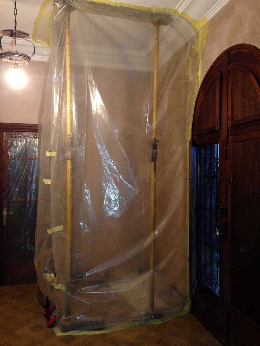 La puerta y la pared de una habitación están cubiertas con láminas de plástico para su construcción.