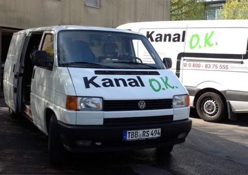 Person reinigt ein Rohr auf einer Straße