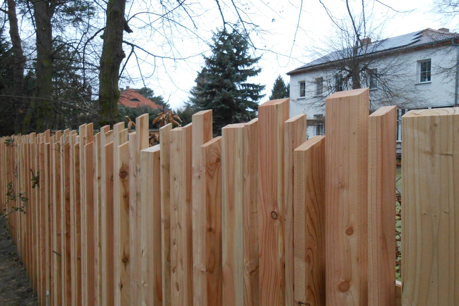 Hoher Zaun aus Naturholz von Holz-König Ernst König OHG um ein Haus, der Sichtschutz bietet