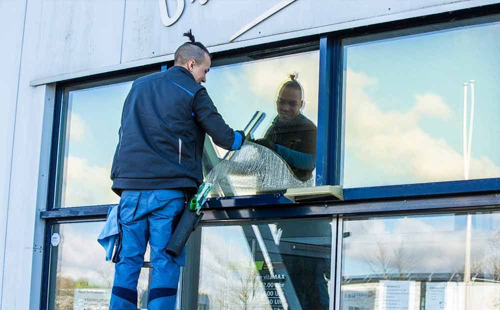 Ein Mann trägt ein schwarzes T-Shirt und lächelt.