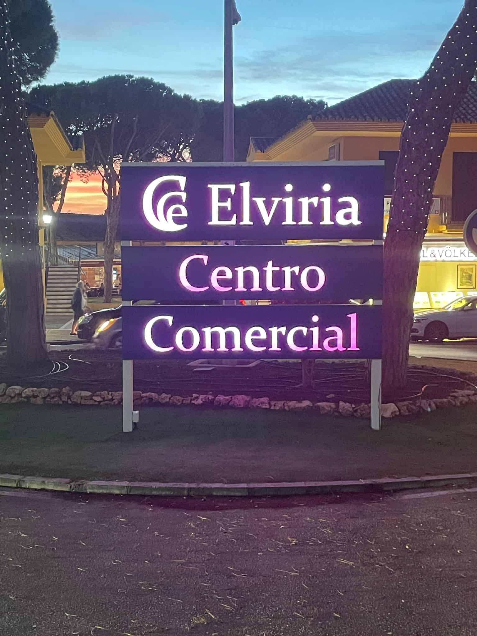 Letrero de Elviria Centro Comercial, un centro comercial, con letras blancas iluminadas sobre un letrero oscuro.