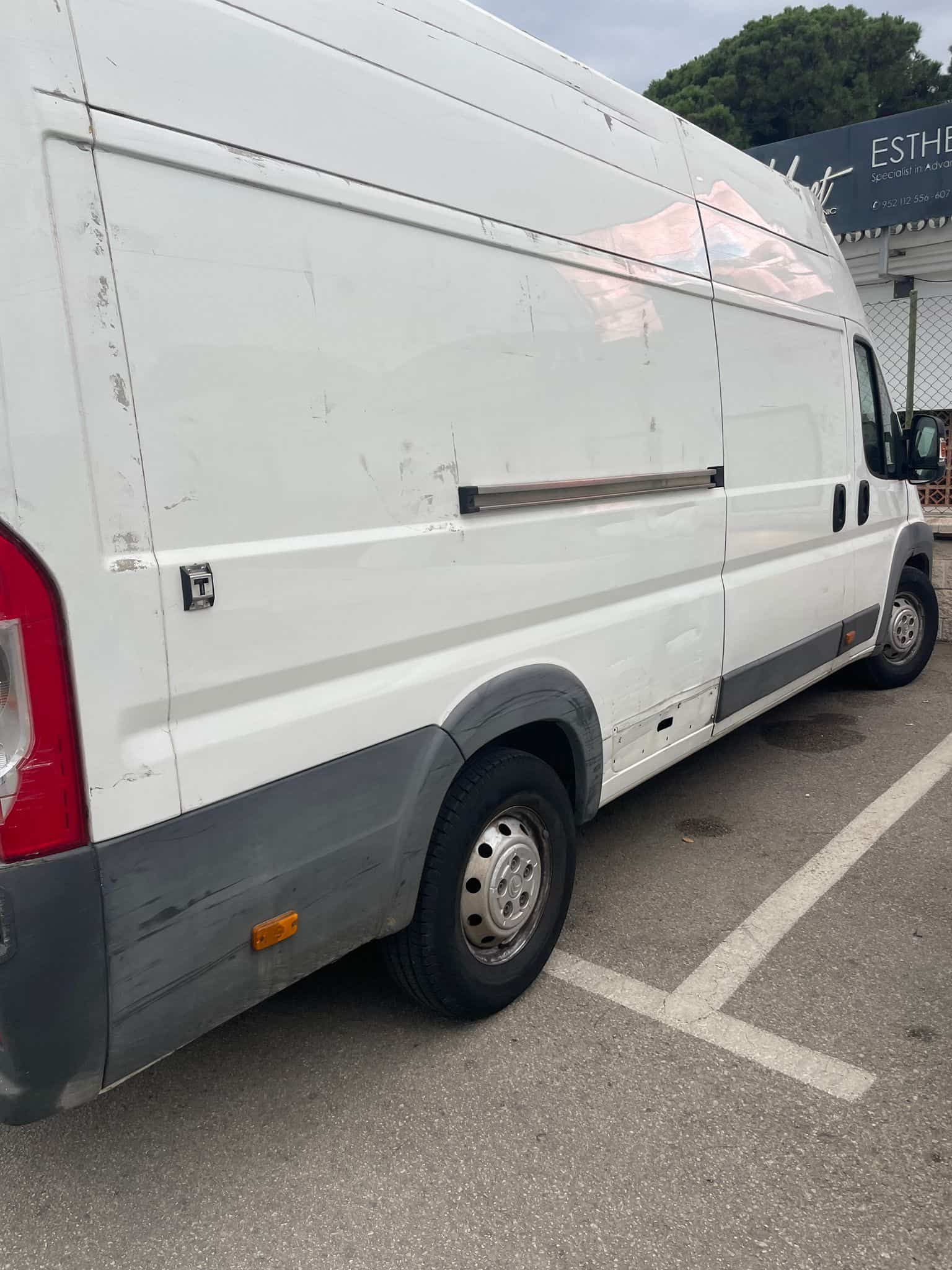 Furgoneta de carga blanca estacionada al aire libre.