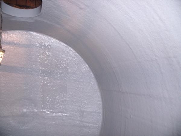 Interior de un tanque cilíndrico blanco y curvo, posiblemente para almacenamiento. 