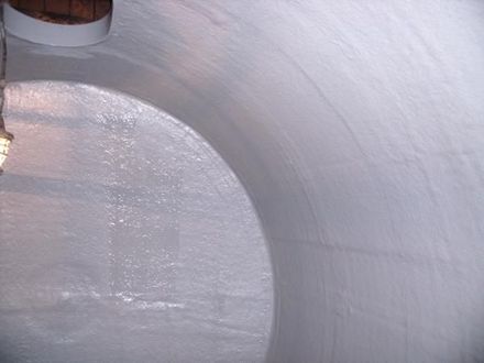 Interior de un tanque cilíndrico blanco y curvo, posiblemente para almacenamiento. 