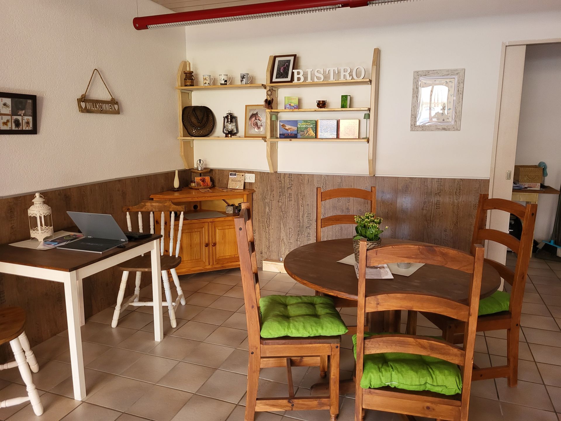 Ein Esszimmer mit einem Tisch und Stühlen und einem Laptop auf dem Tisch.