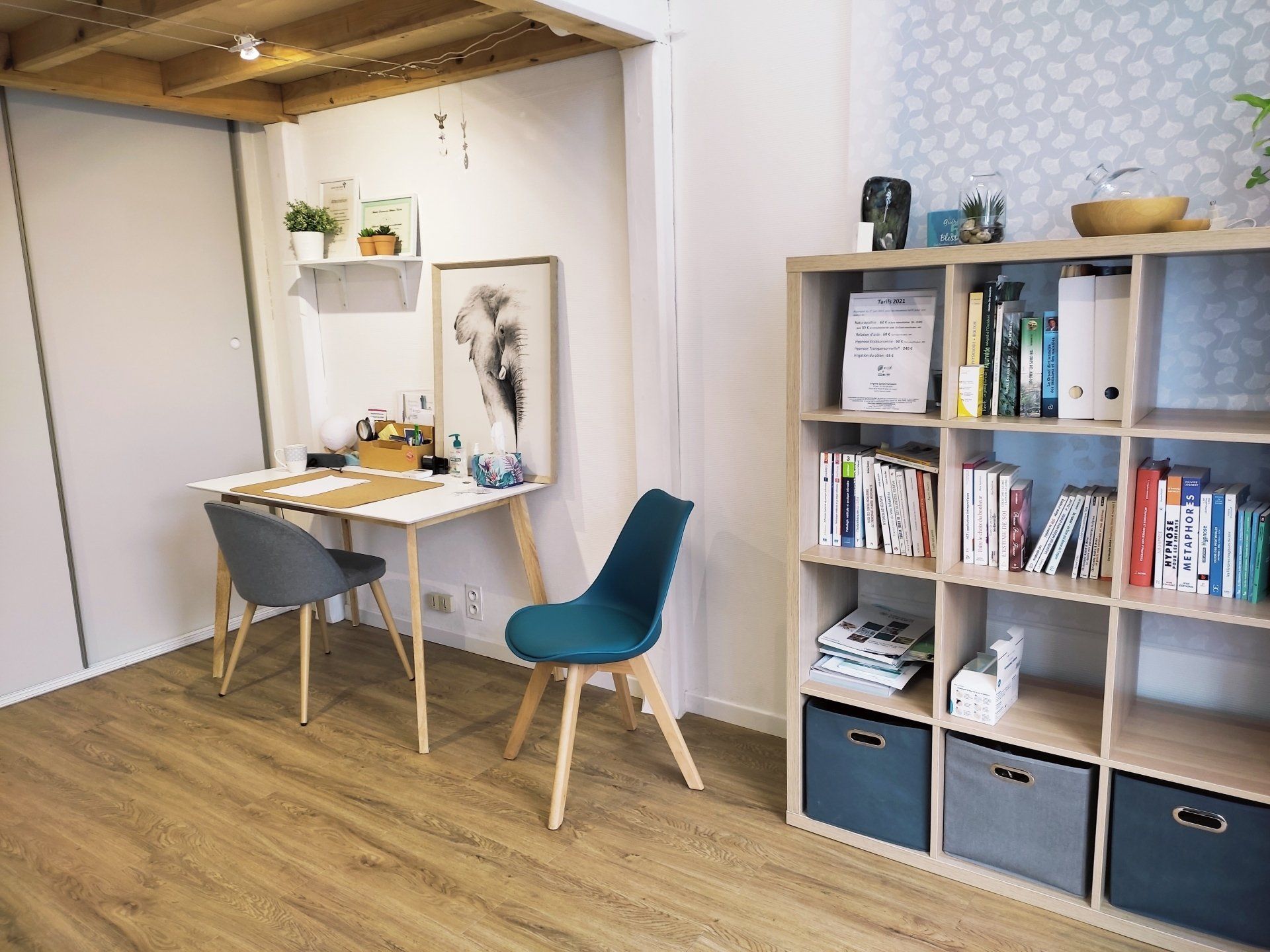 Petit bureau à domicile avec une table et des chaises, une bibliothèque et des objets décoratifs.