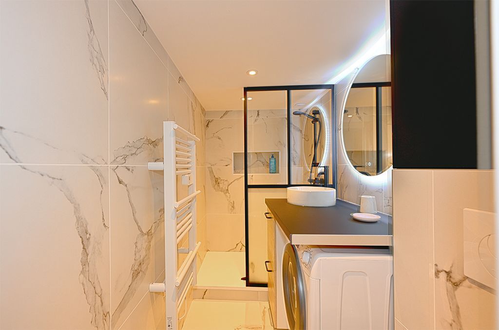 Salle de bains complète avec douche, sèche-serviette et vasque