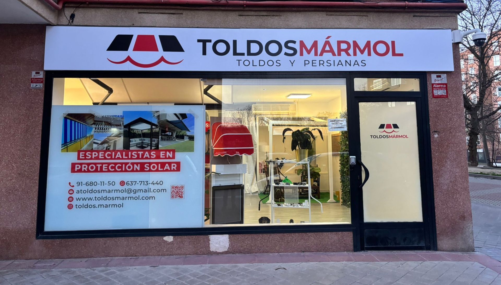 Un escaparate con un cartel que dice toldos y persianas.